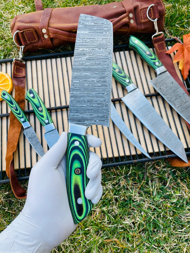 Full view of a 5-piece Damascus steel kitchen knife set with G10 handles, featuring steel bolsters