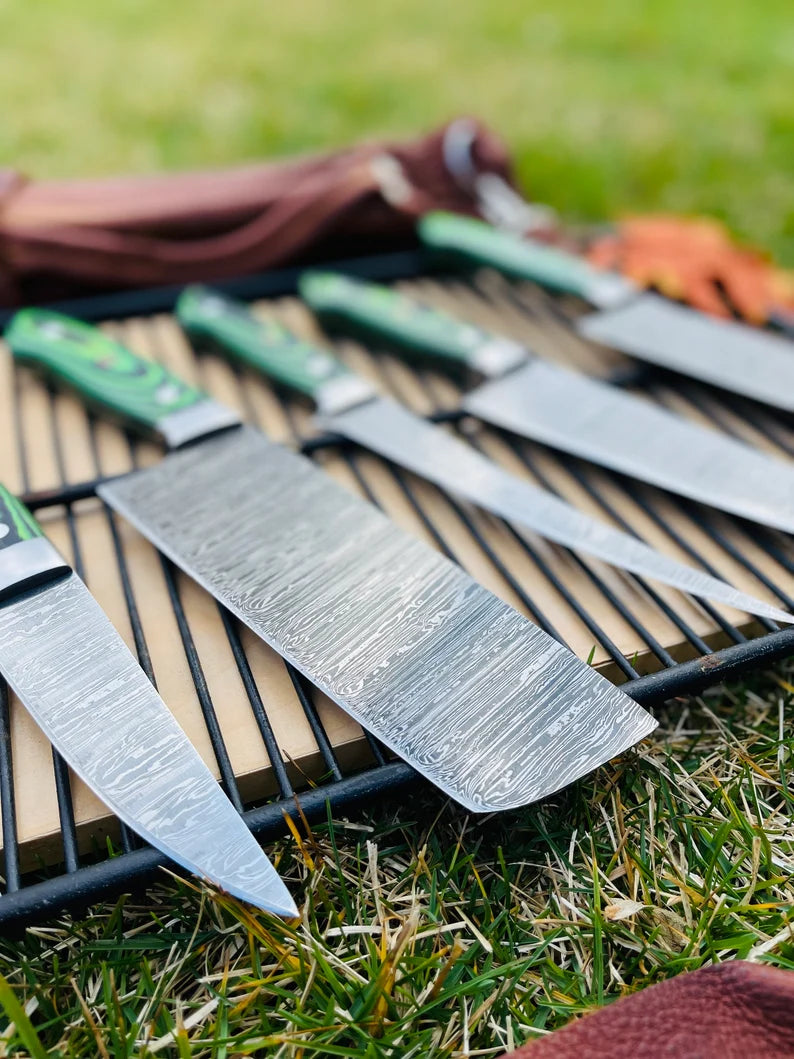 Professional chef Damascus kitchen knives with ergonomic G10 handles displayed in a leather roll kit