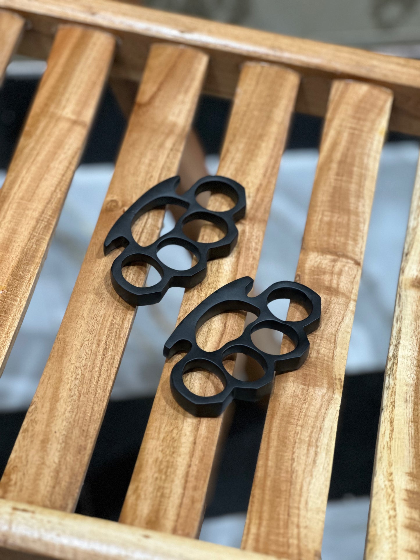 Black steel knuckle duster with custom engravings, featuring a solid brass build and a leather carrying case