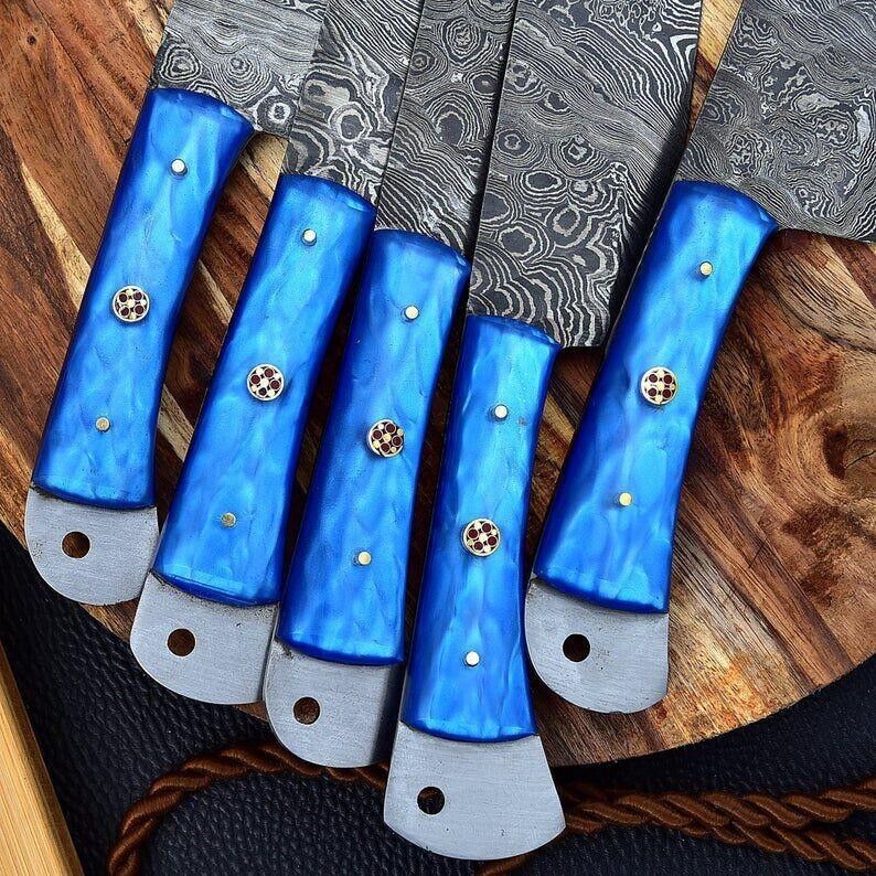 Close-up of a Damascus knife kitchen set featuring sharp, durable blades ranging from 9 to 13 inches.
