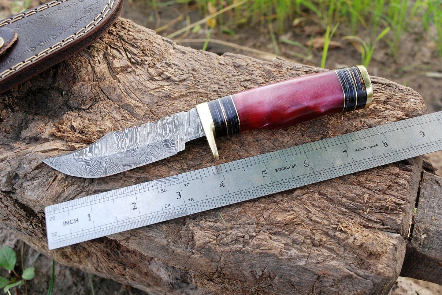 Custom 8-inch Damascus steel hunting knife with resin handle and brass guard.