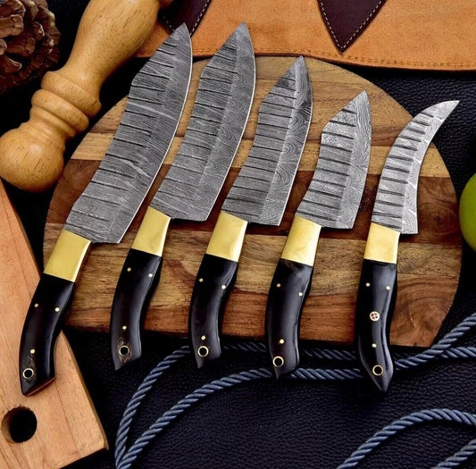 Custom handmade Damascus steel knife set featuring 9 to 13-inch hand-forged blades, buffalo horn handles, and brass bolsters, displayed on a wooden surface