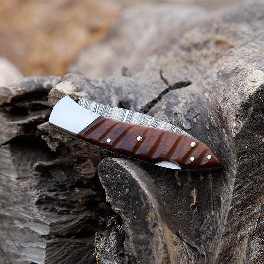 Custom handmade Damascus steel pocket knife with rosewood handle and steel bolster.