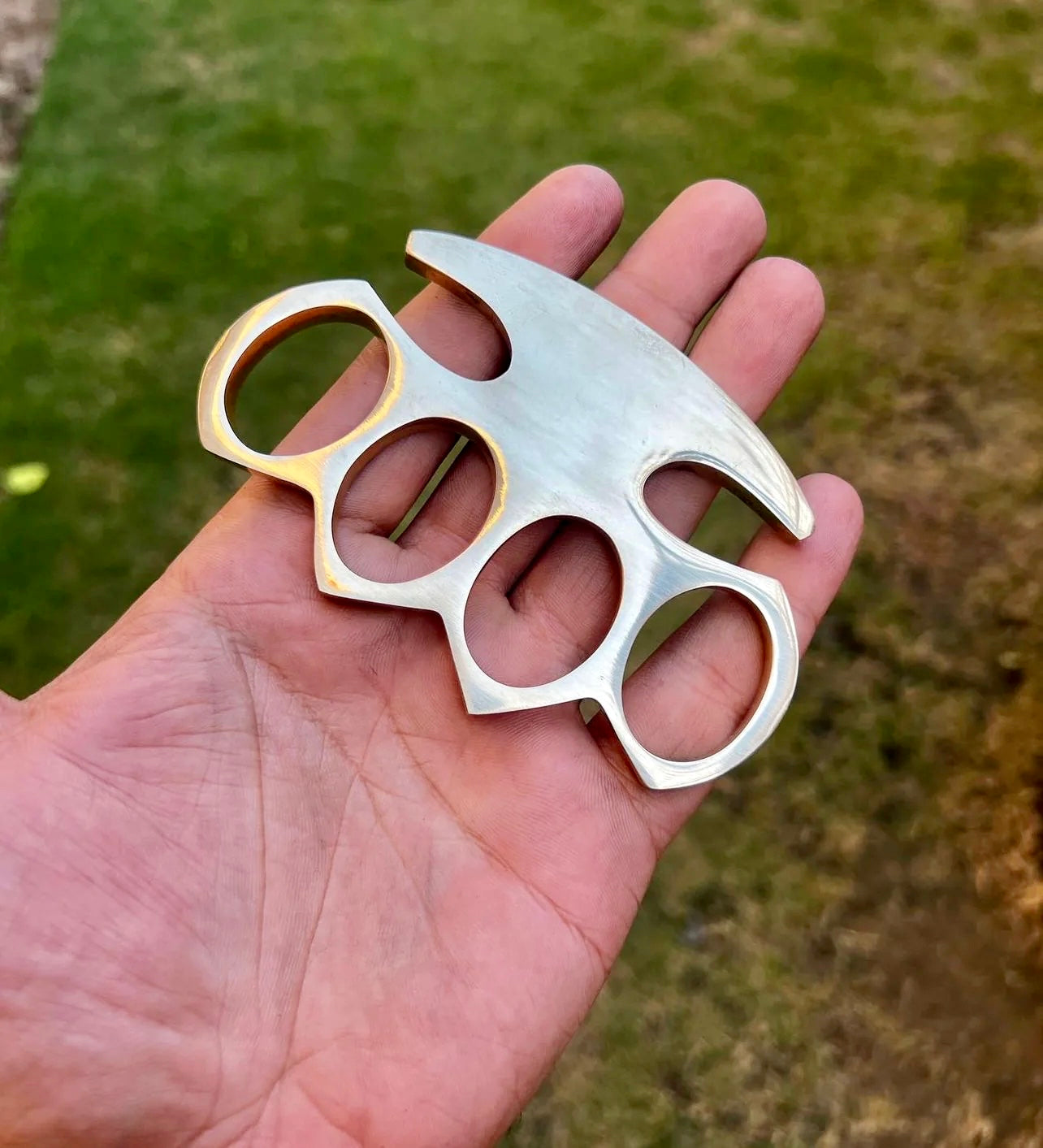 Custom solid brass knuckle displayed with a premium leather belt loop case