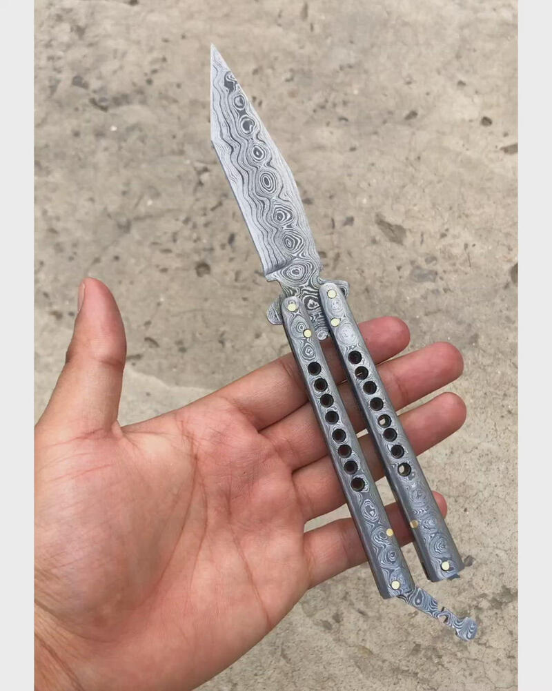 Damascus Balisong Butterfly Knife with Damascus steel handle and blade, displayed with a leather sheath