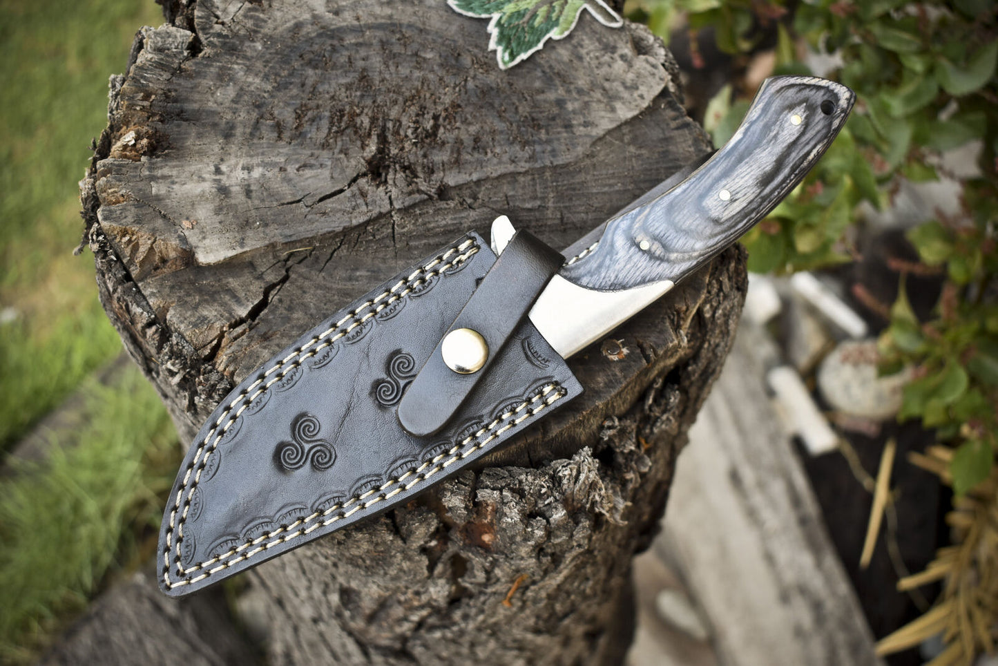 Damascus steel hunting knife with ergonomic pakkawood handle, perfect for outdoor use.