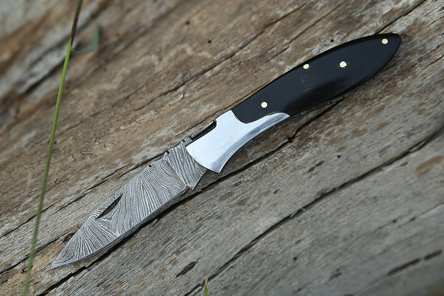 Damascus steel pocket knife with buffalo horn handle and steel bolster, includes leather sheath