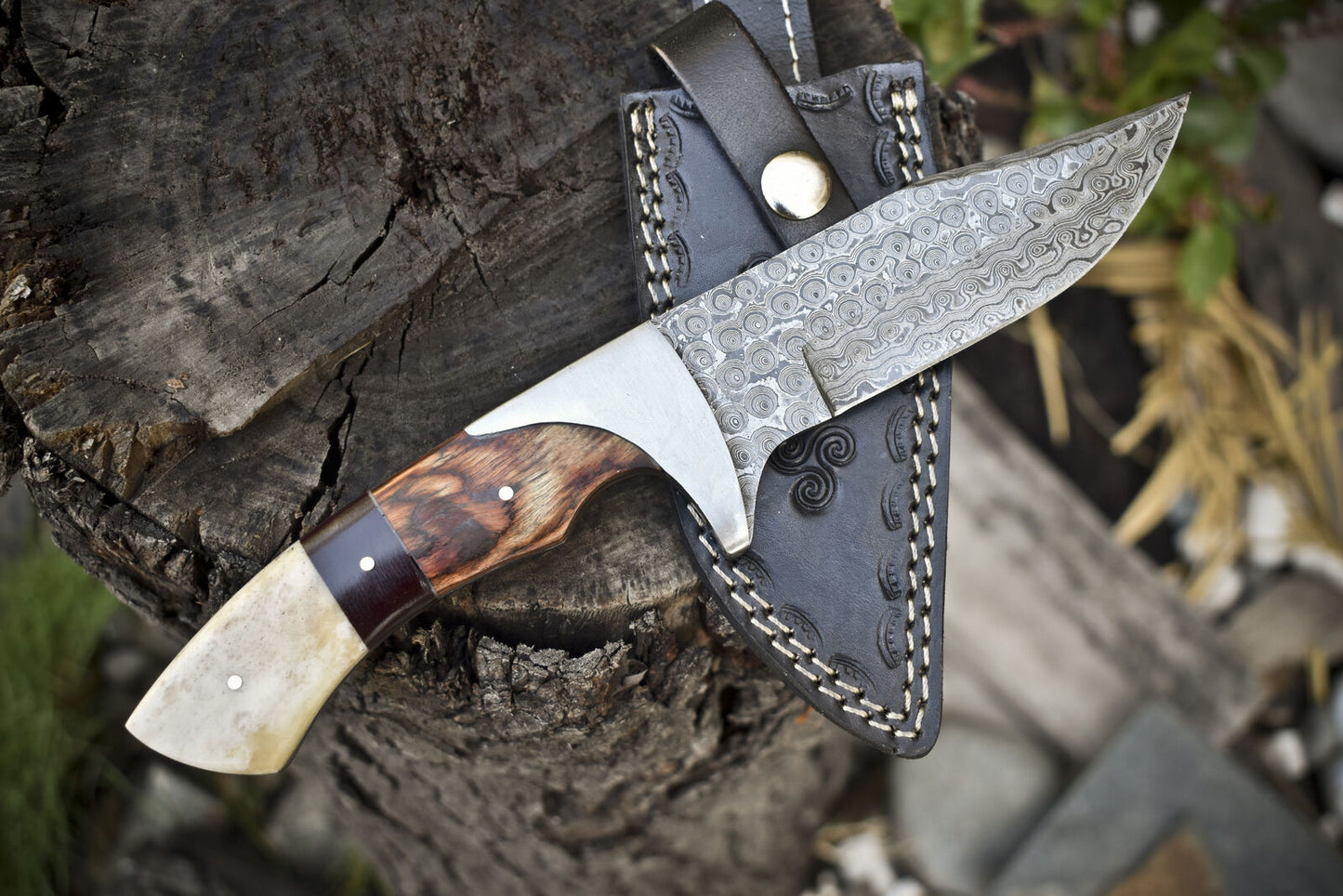 Elegant Damascus steel hunting knife with camel bone handle and leather sheath for hunting.