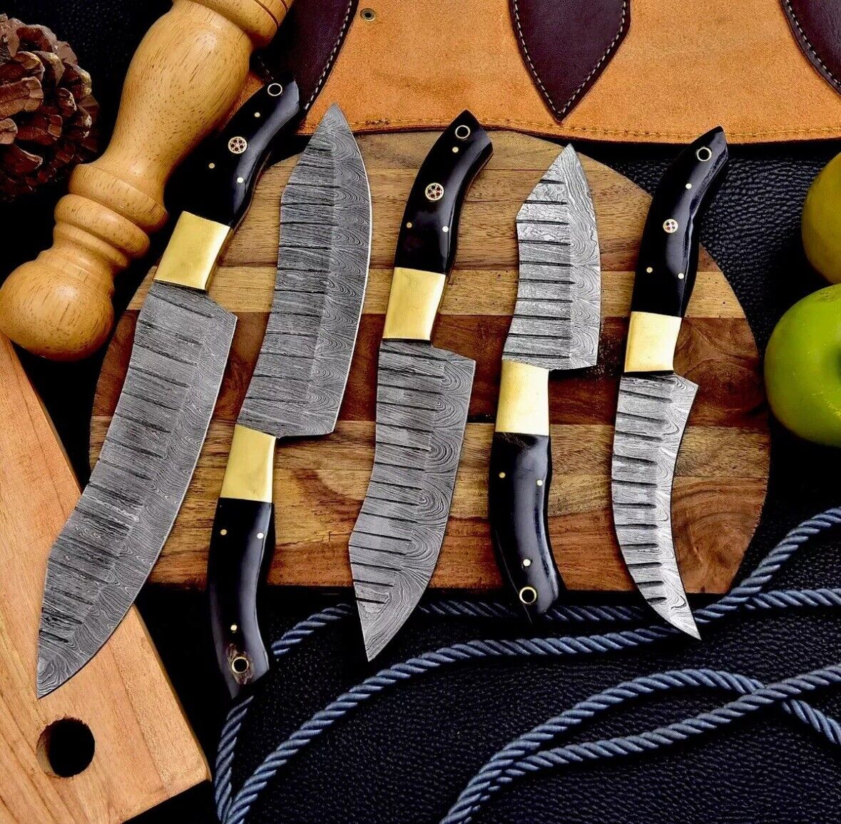 Elegant Damascus steel knife set with hand-forged blades ranging from 9 to 13 inches, showcasing buffalo horn handles and brass bolsters against a rustic backdrop