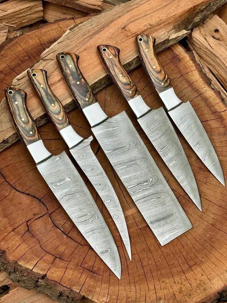 Full view of custom Damascus steel kitchen knife set with pakkawood handles and steel bolsters, blades ranging from 3 to 8 inches