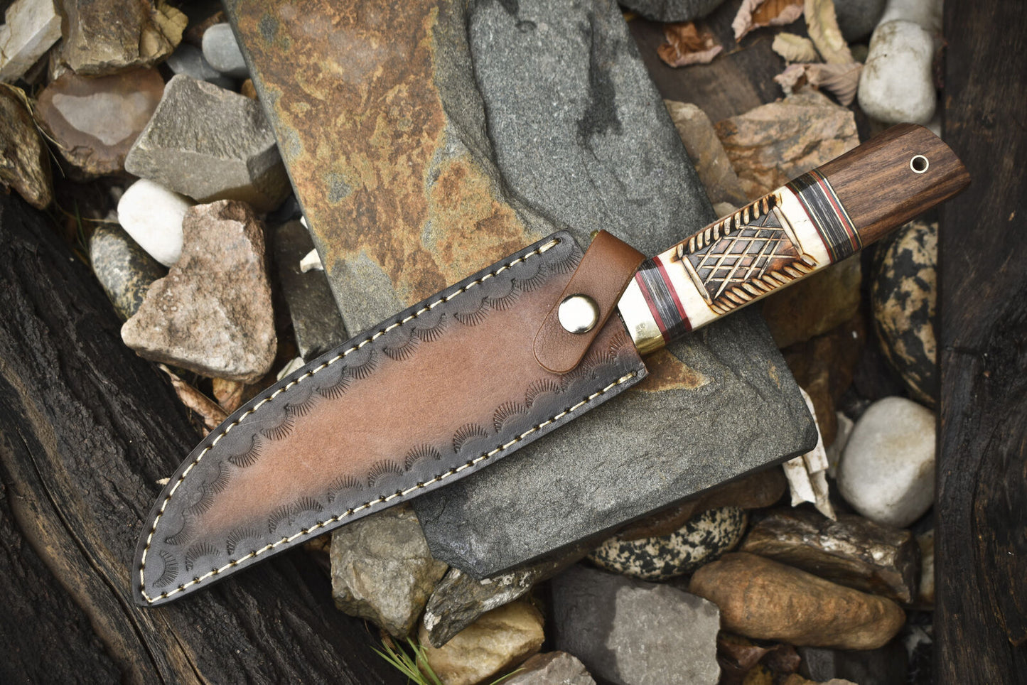 Hand-forged Damascus steel Bowie knife with leather sheath, brass guard, and camel bone rosewood handle