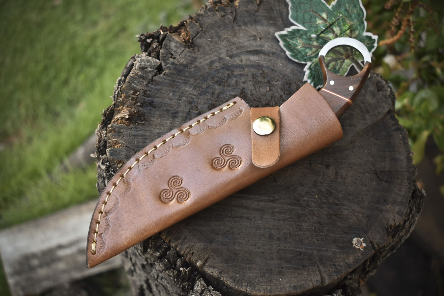 "Handmade Damascus hunting knife with 8.5-inch blade and pakkawood handle, complete with leather sheath for safety