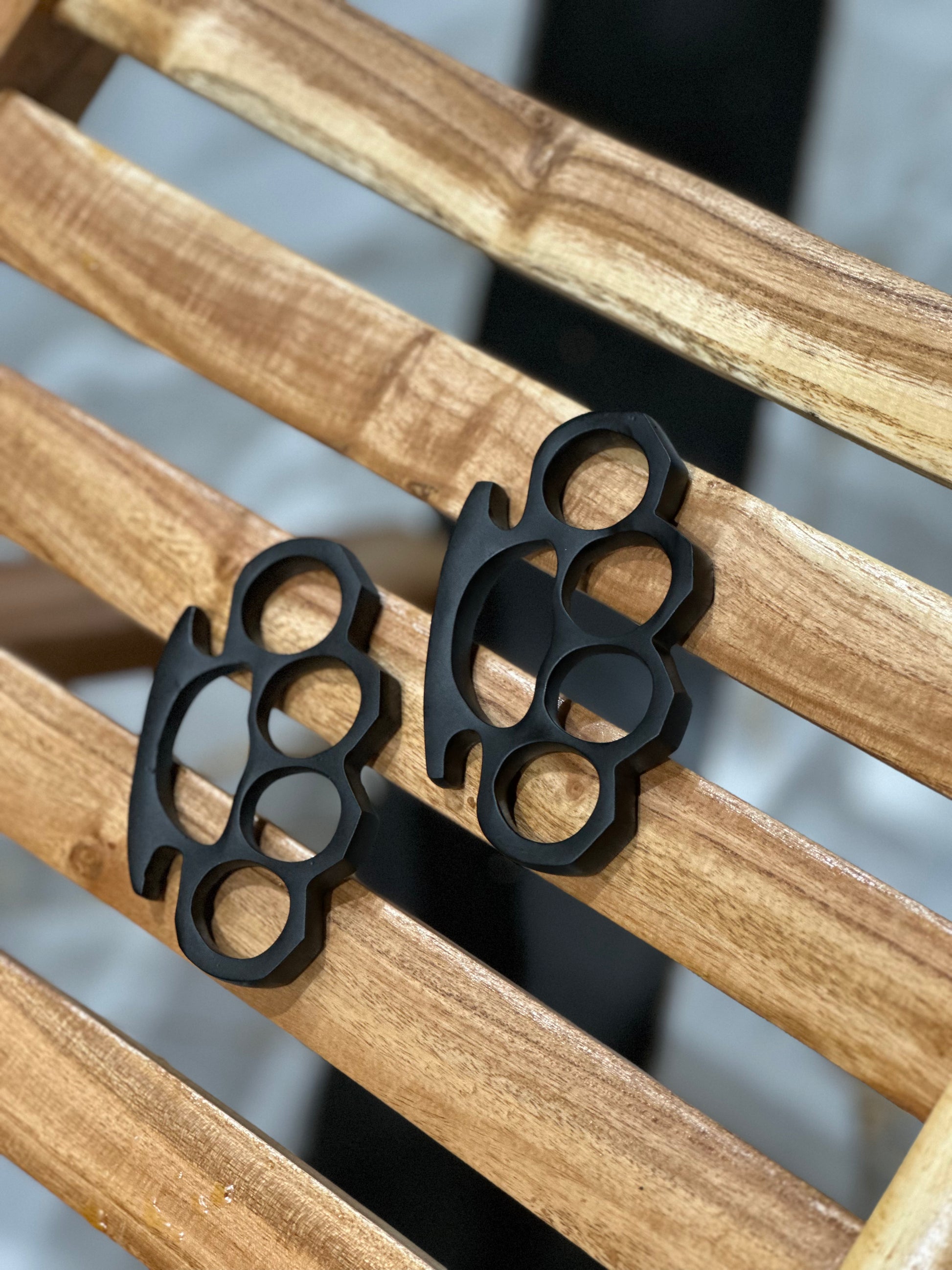 Personalized black steel knuckle duster with a handcrafted belt loop leather case, ideal for self-defense and everyday carry