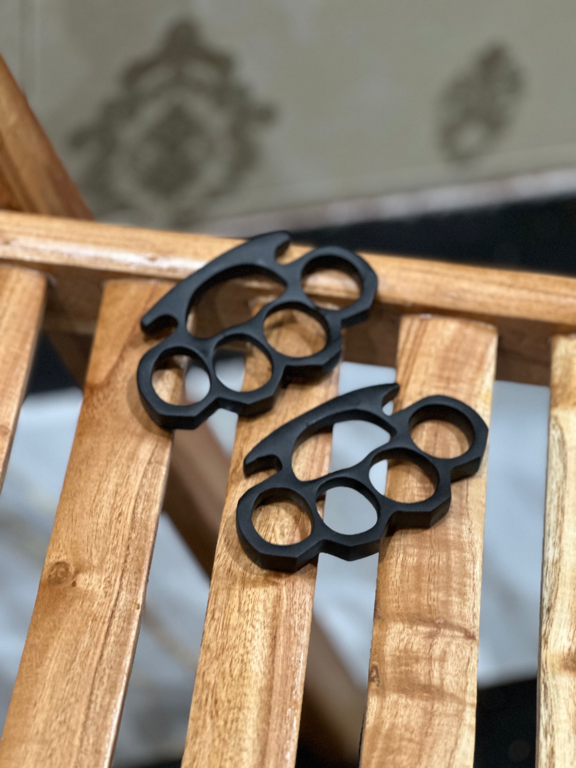 Unique custom engraved black steel knuckle duster in solid brass, shown with a premium leather belt loop case