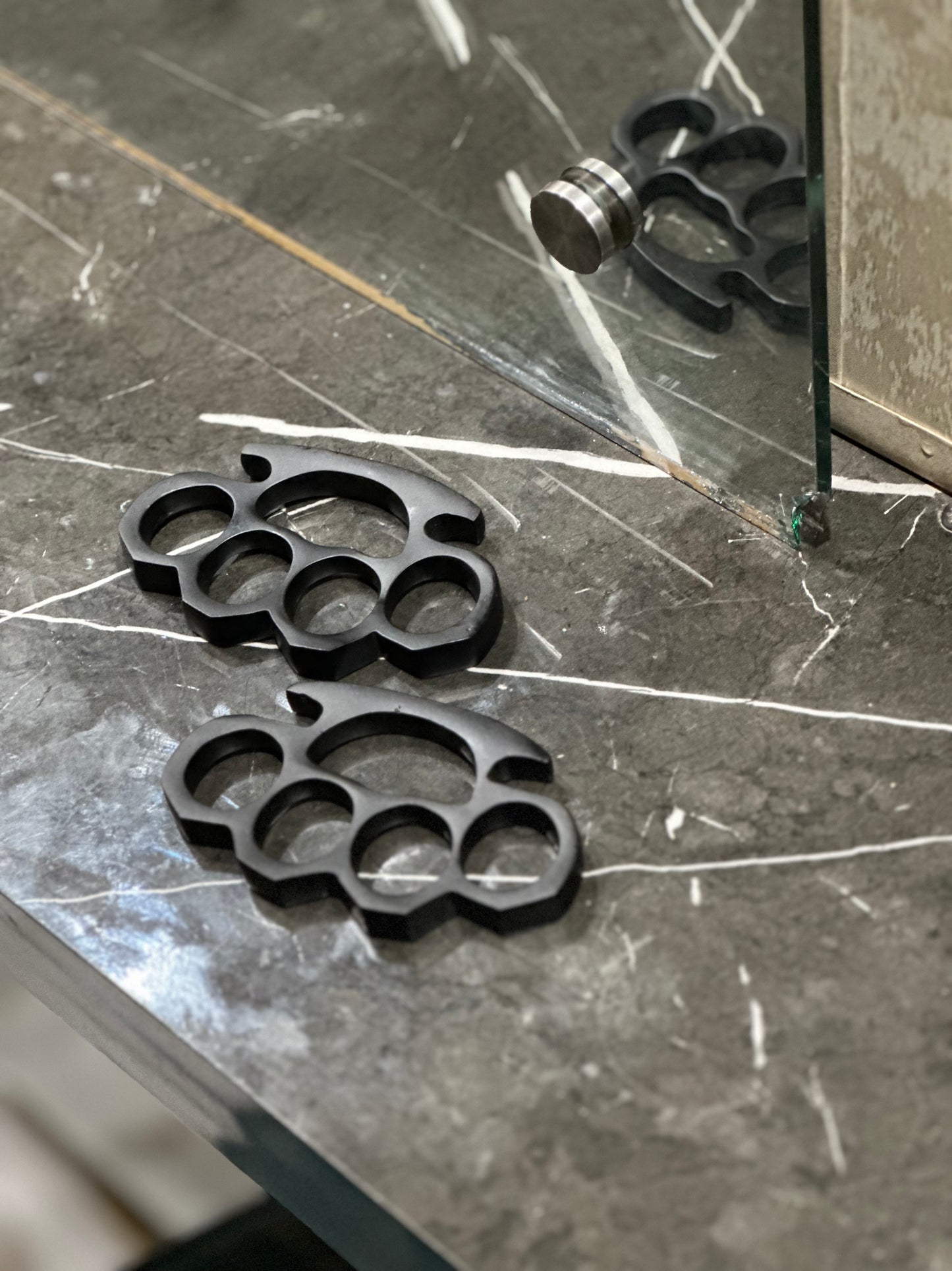 handmade black steel knuckle duster with solid brass construction, paired with a belt loop leather case