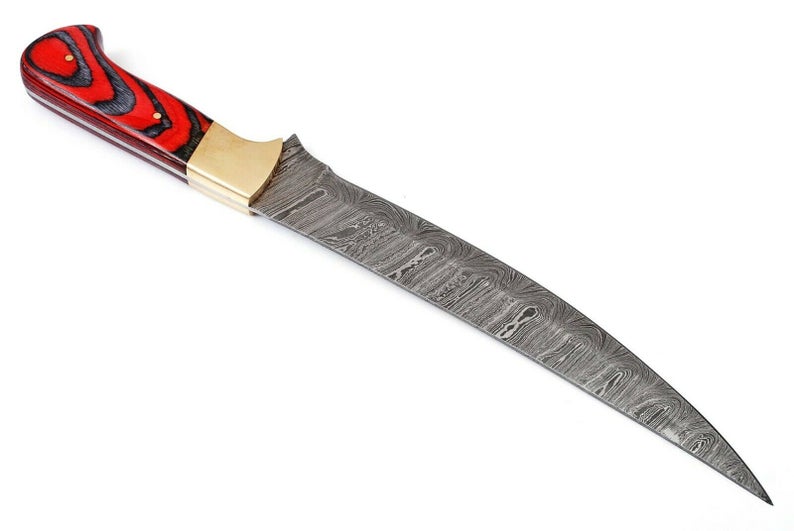 Close-up of a 12-inch Damascus fillet knife featuring an exotic wood handle and brass bolster, shown with a leather sheath