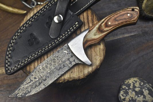 0-inch J2 steel hunting knife featuring a pakkawood handle and steel bolster, resting on a leather sheath.