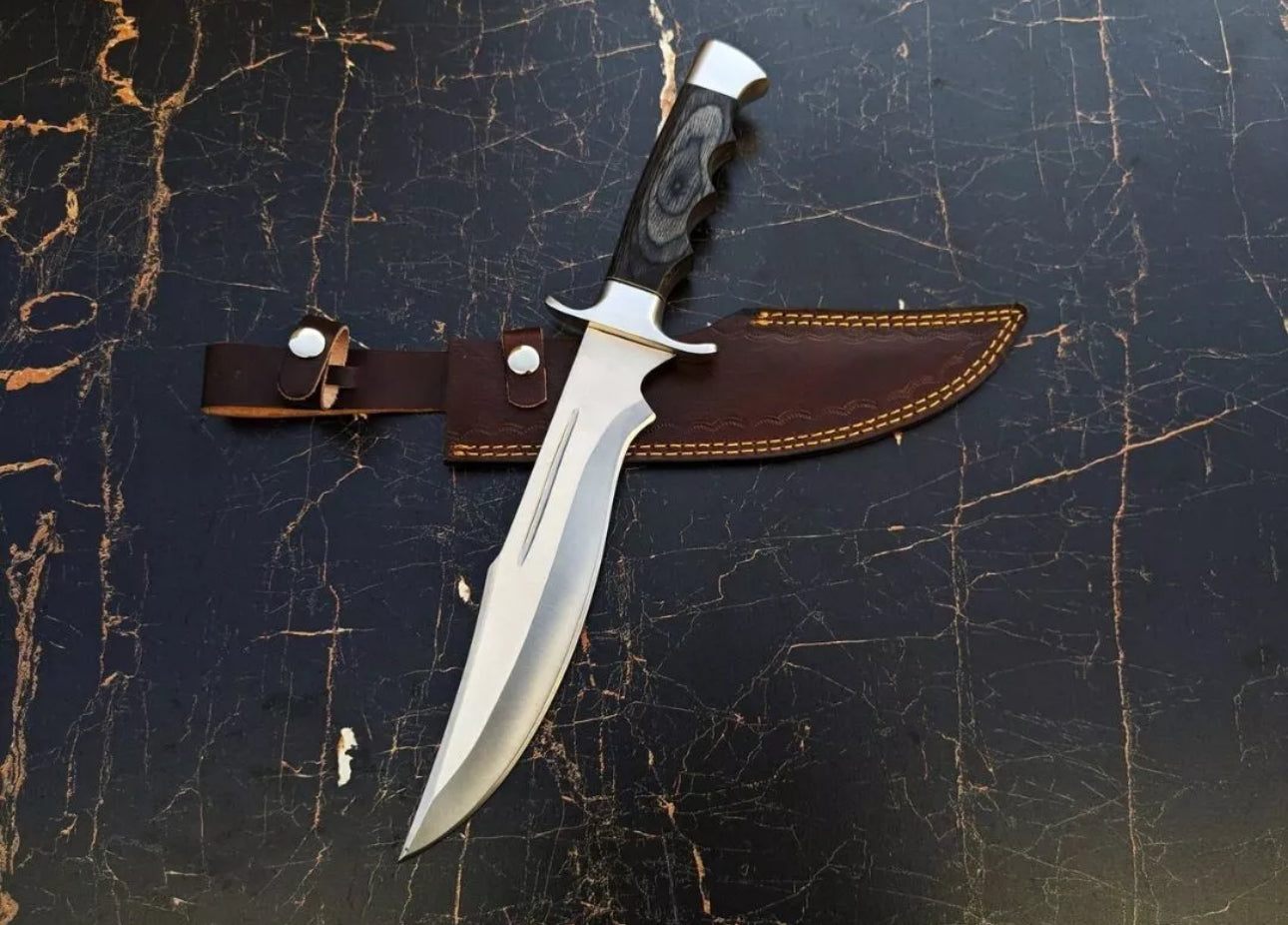 Custom handmade J2 steel Bowie knife with a steel guard, dollar handle, and leather sheath.