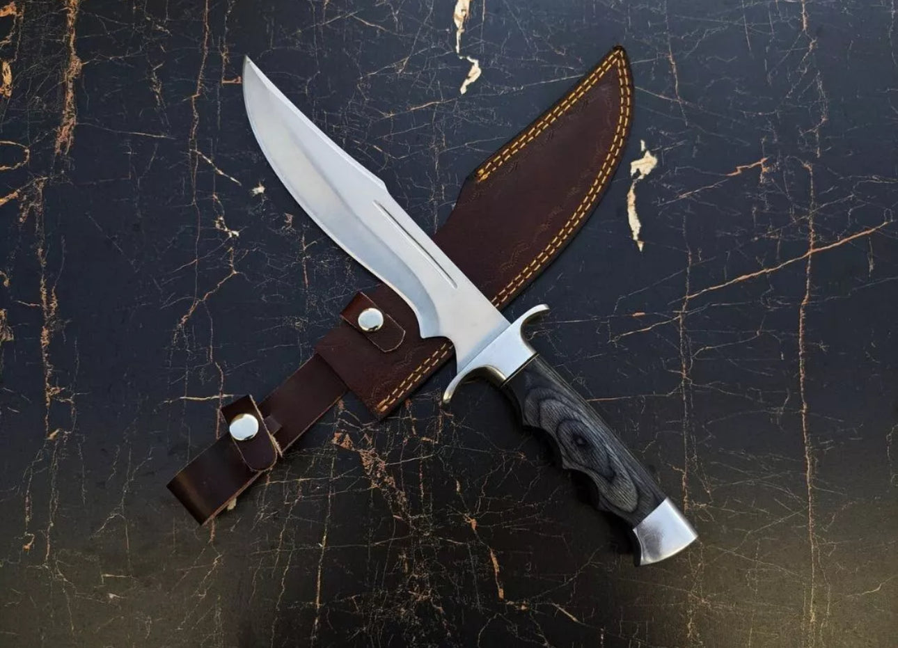 Custom handmade J2 steel Bowie knife with a steel guard, dollar handle, and leather sheath.