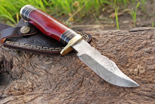 Custom 8-inch Damascus steel hunting knife with resin handle and brass guard.