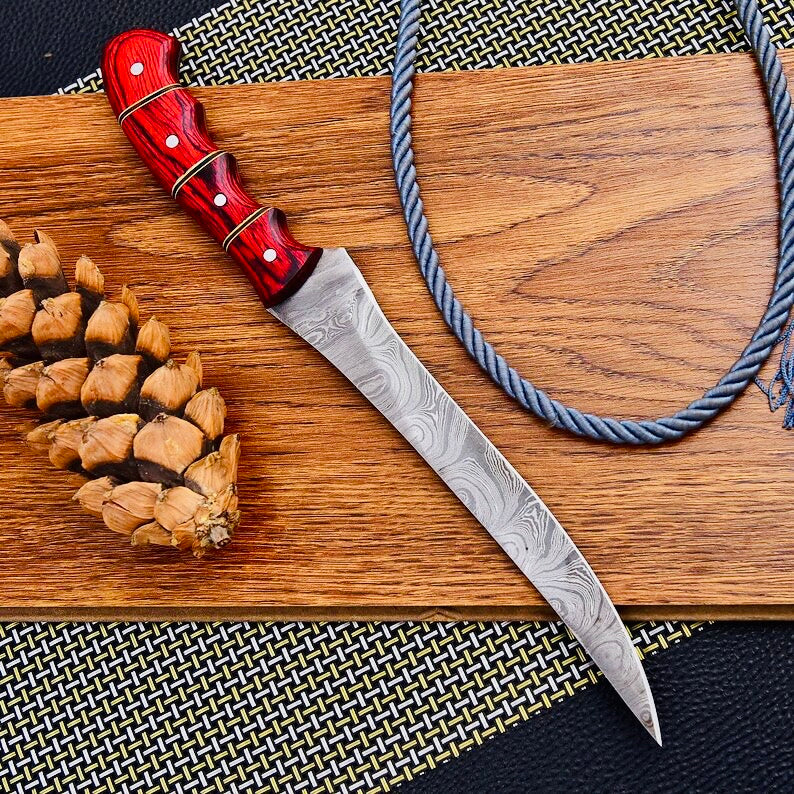 Custom handmade Damascus steel fishing fillet knife with a 13-inch blade, Pakka wood handle, and leather sheath, showcasing the sharp edge and premium craftsmanship