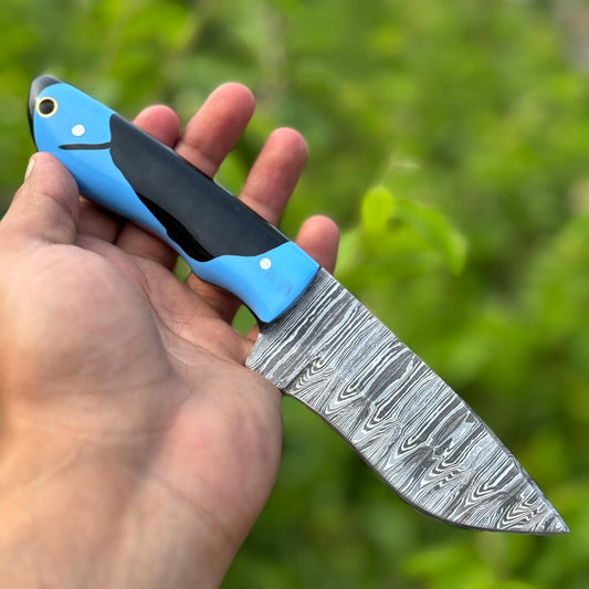 Custom handmade Damascus steel hunting knife with a resin handle and leather sheath, showcasing its unique craftsmanship