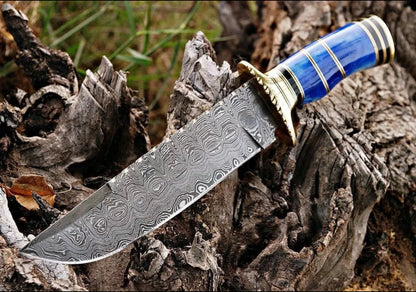 Custom handmade Damascus steel Bowie knife with a brass guard, color bone handle, and leather sheath.