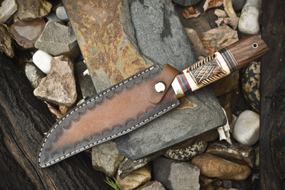 Hand-forged Damascus steel Bowie knife with leather sheath, brass guard, and camel bone rosewood handle