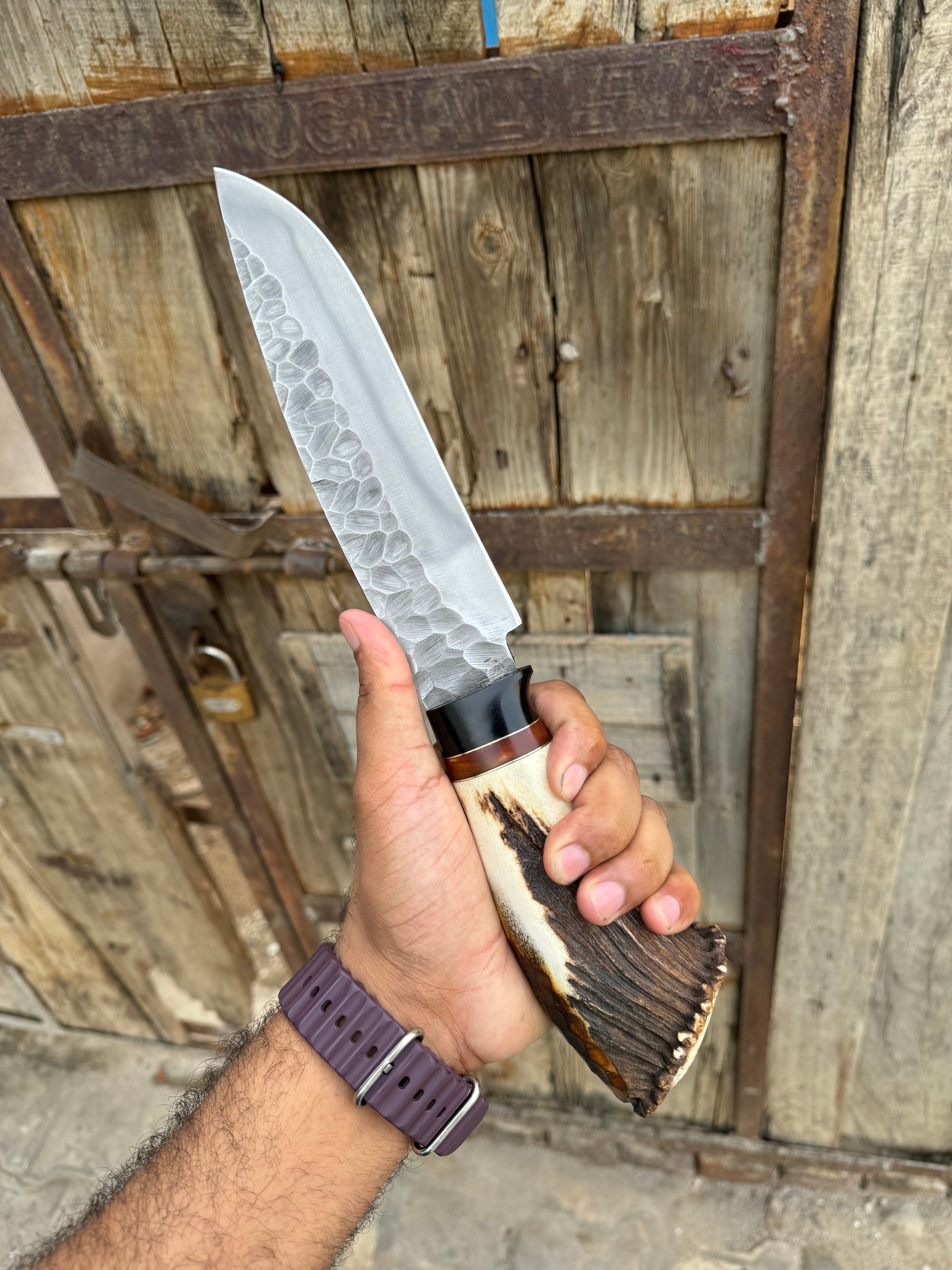 Handmade D2 steel Bowie knife with a 13-inch blade, stag crown handle, and a classic leather sheath for outdoor use