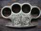 Handmade custom brass knuckle with intricate engravings and a leather belt loop case for secure carrying