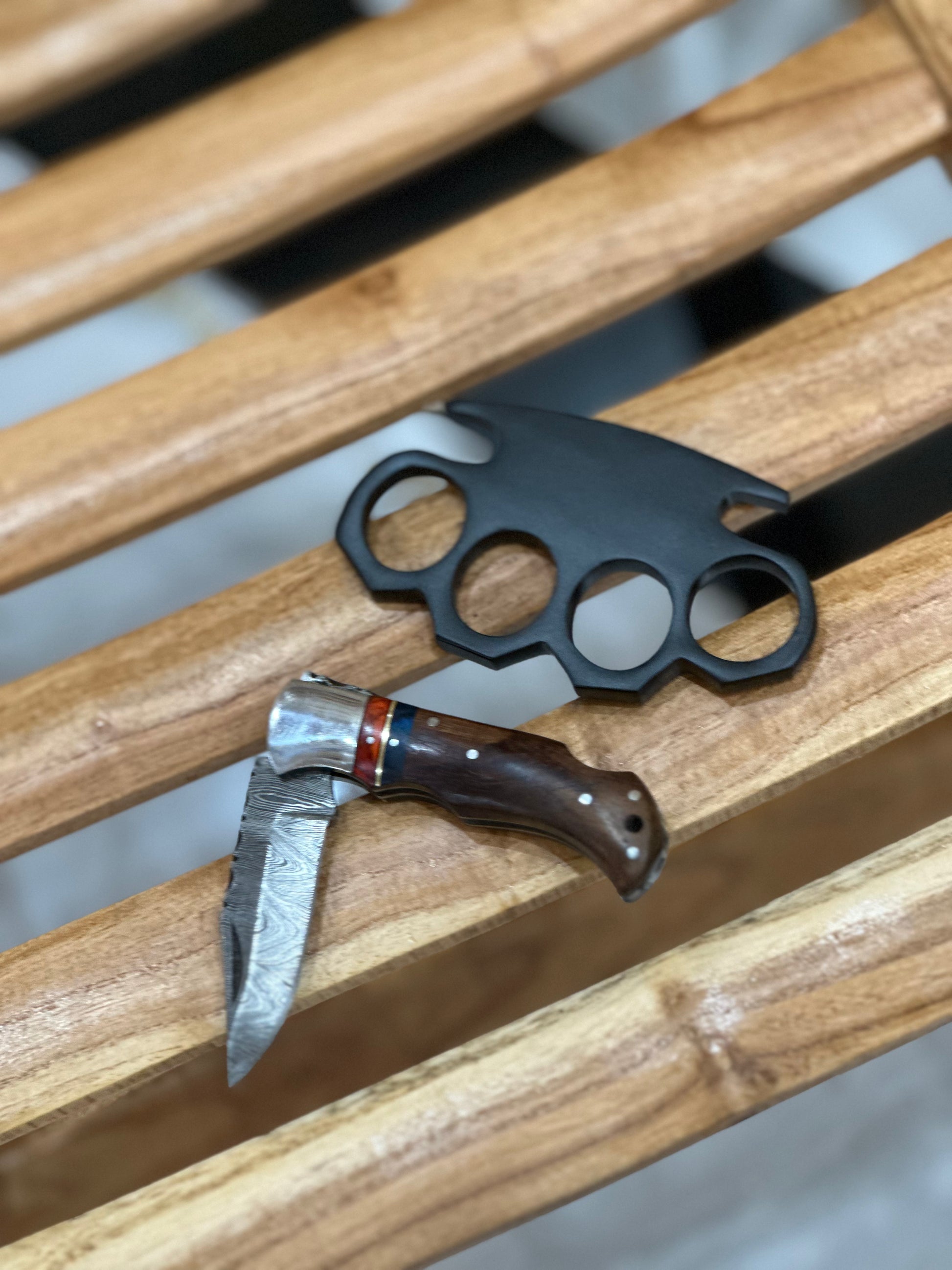 Personalized black steel knuckle duster with a pocket knife, shown with a premium belt loop leather case for everyday carry