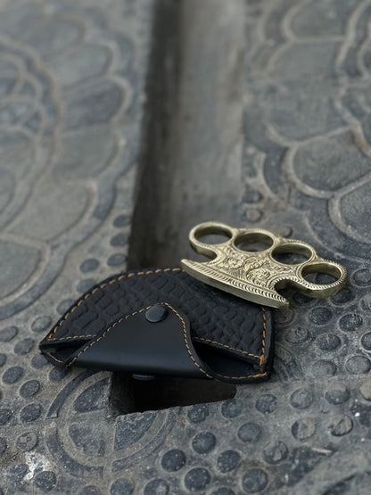 "Pure brass engraved brass knuckles displayed with a premium belt loop leather case."
