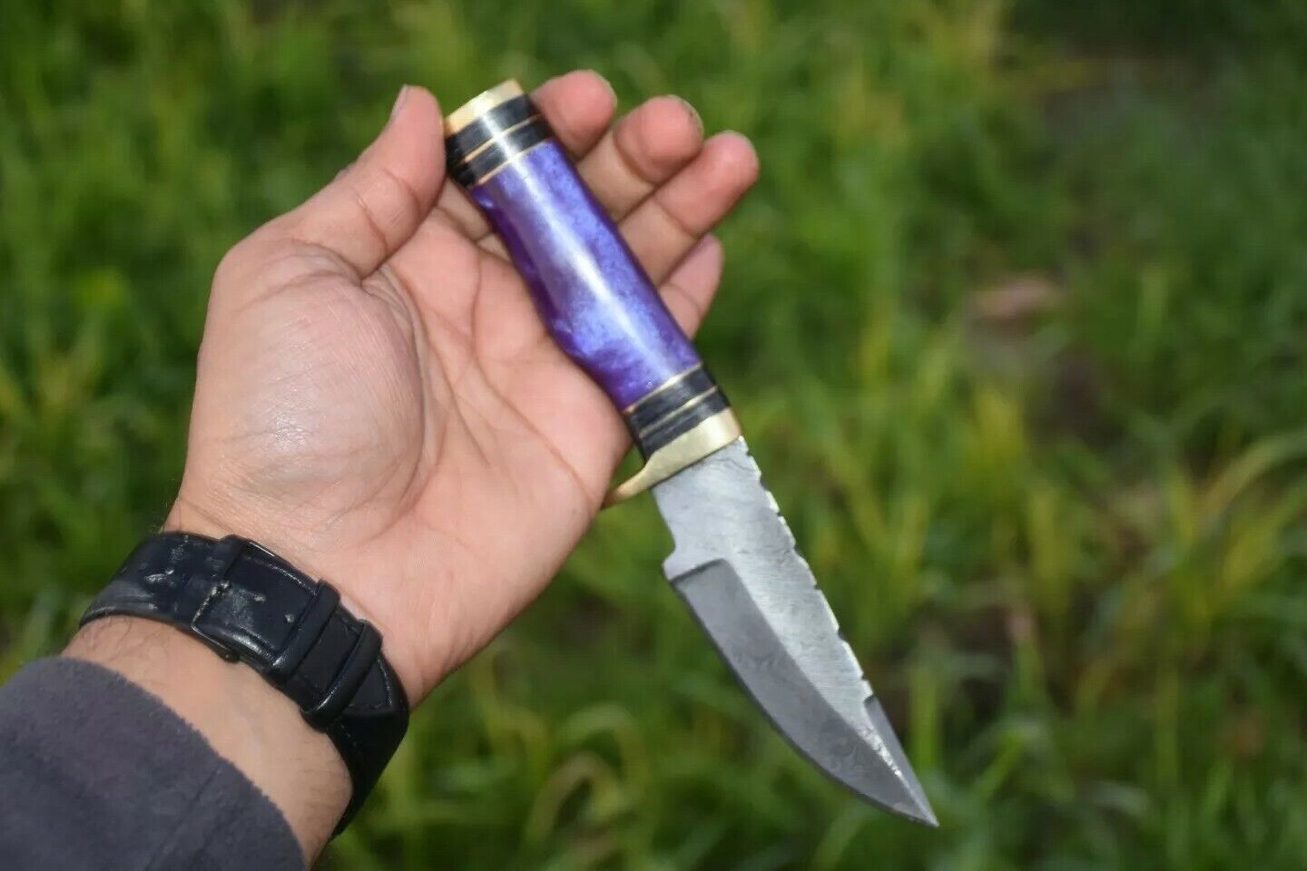 Side view of the custom-made 8-inch Damascus steel hunting knife with leather sheath.
