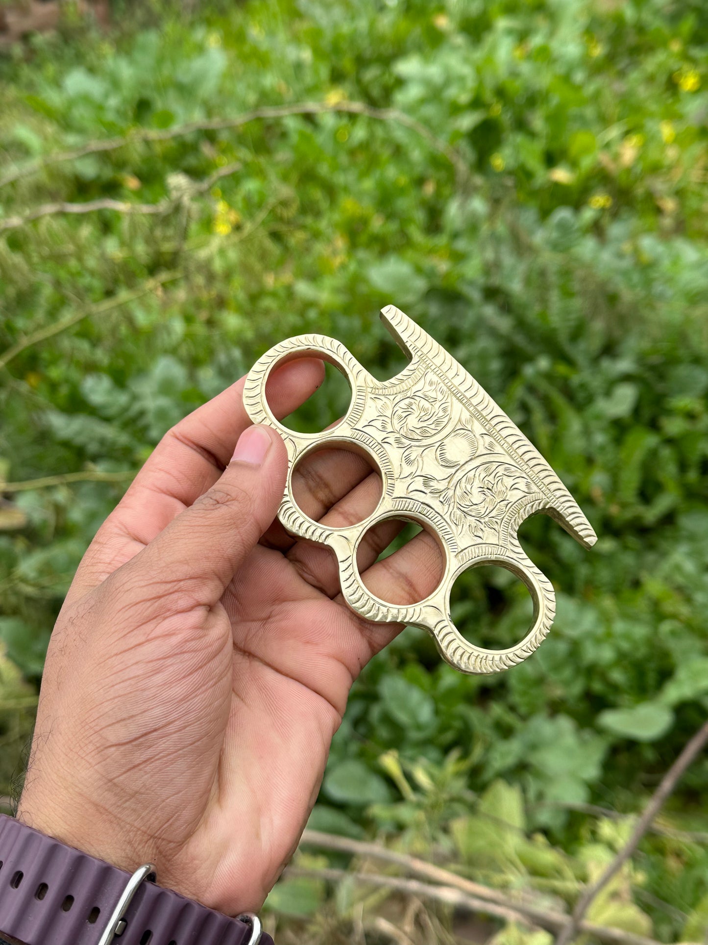 Solid brass knuckle duster with detailed engraving and belt loop leather case