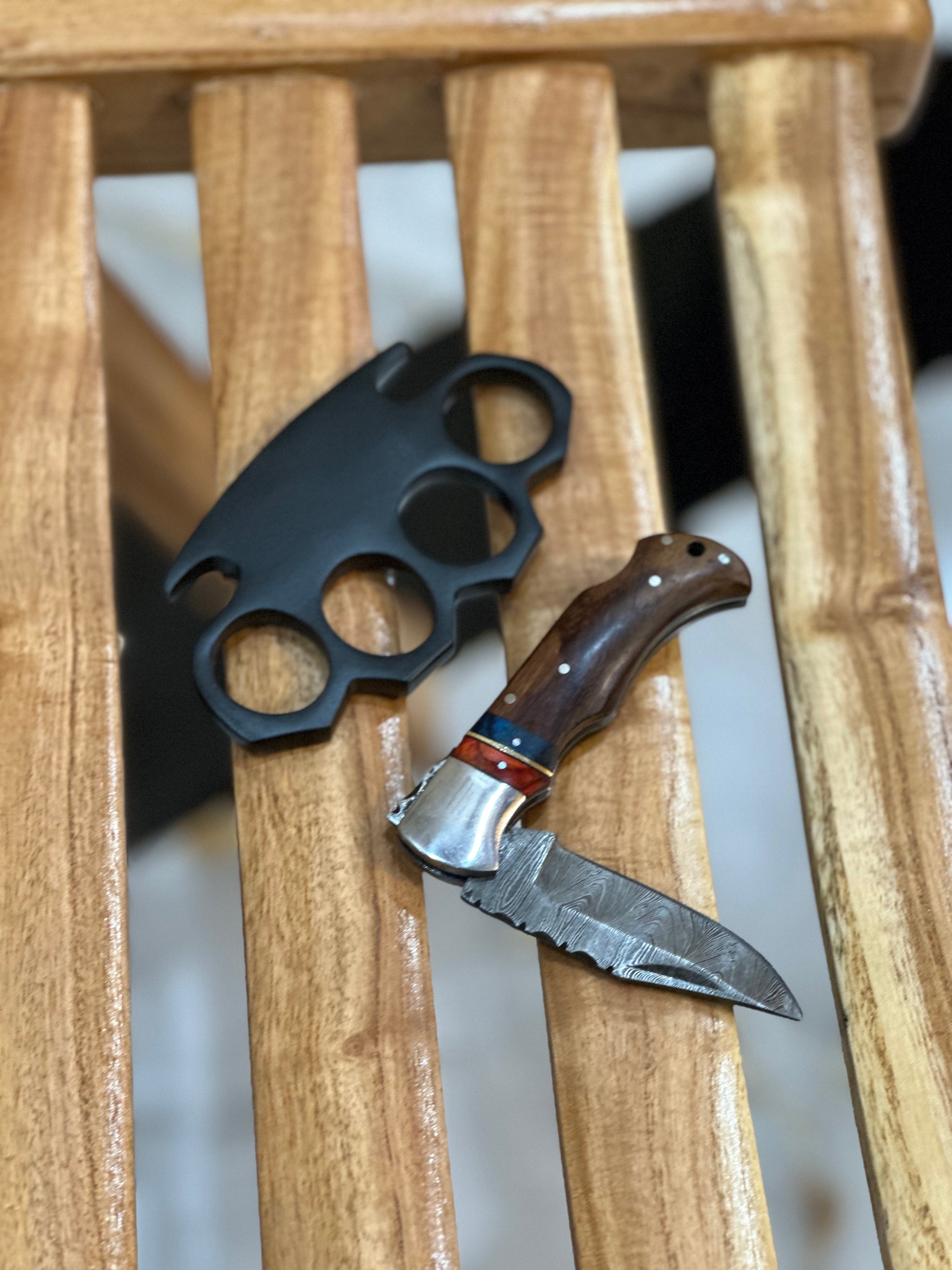 Unique custom engraved black steel knuckle duster with solid brass construction, pocket knife, and leather case