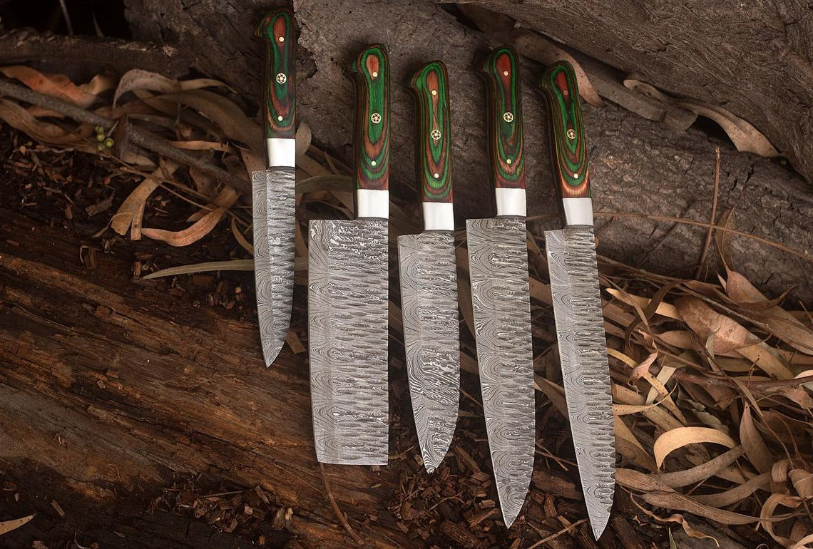 Artistic arrangement of a handmade Damascus kitchen knife set, featuring unique twisted steel bolsters and wooden handles