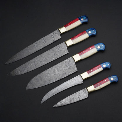 Close-up of Damascus knife set with patterned blades, camel bone, pakkawood handles, and steel bolster, ideal for chefs and kitchen enthusiasts