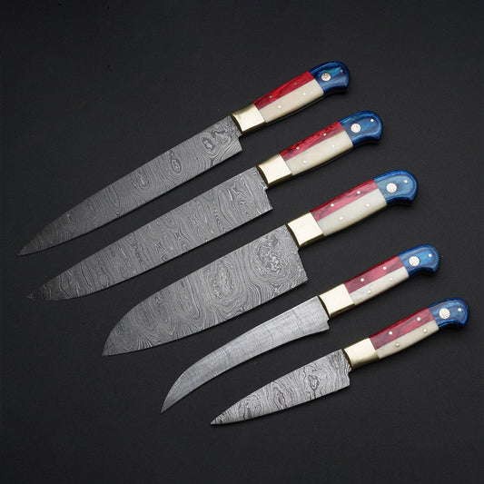 Close-up of Damascus knife set with patterned blades, camel bone, pakkawood handles, and steel bolster, ideal for chefs and kitchen enthusiasts