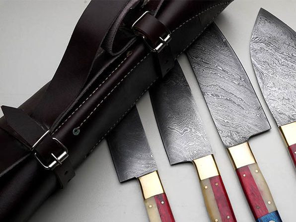 Close-up of a custom handmade Damascus steel knife set, highlighting the intricate blade patterns and sturdy camel bone handle