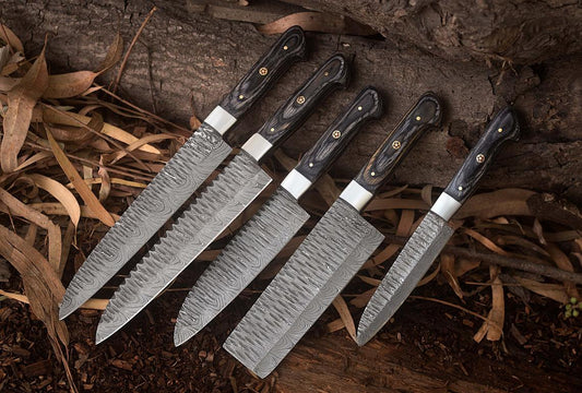 Custom handmade Damascus kitchen knives set with exotic wood handles and steel bolsters, featuring a twisted pattern blade